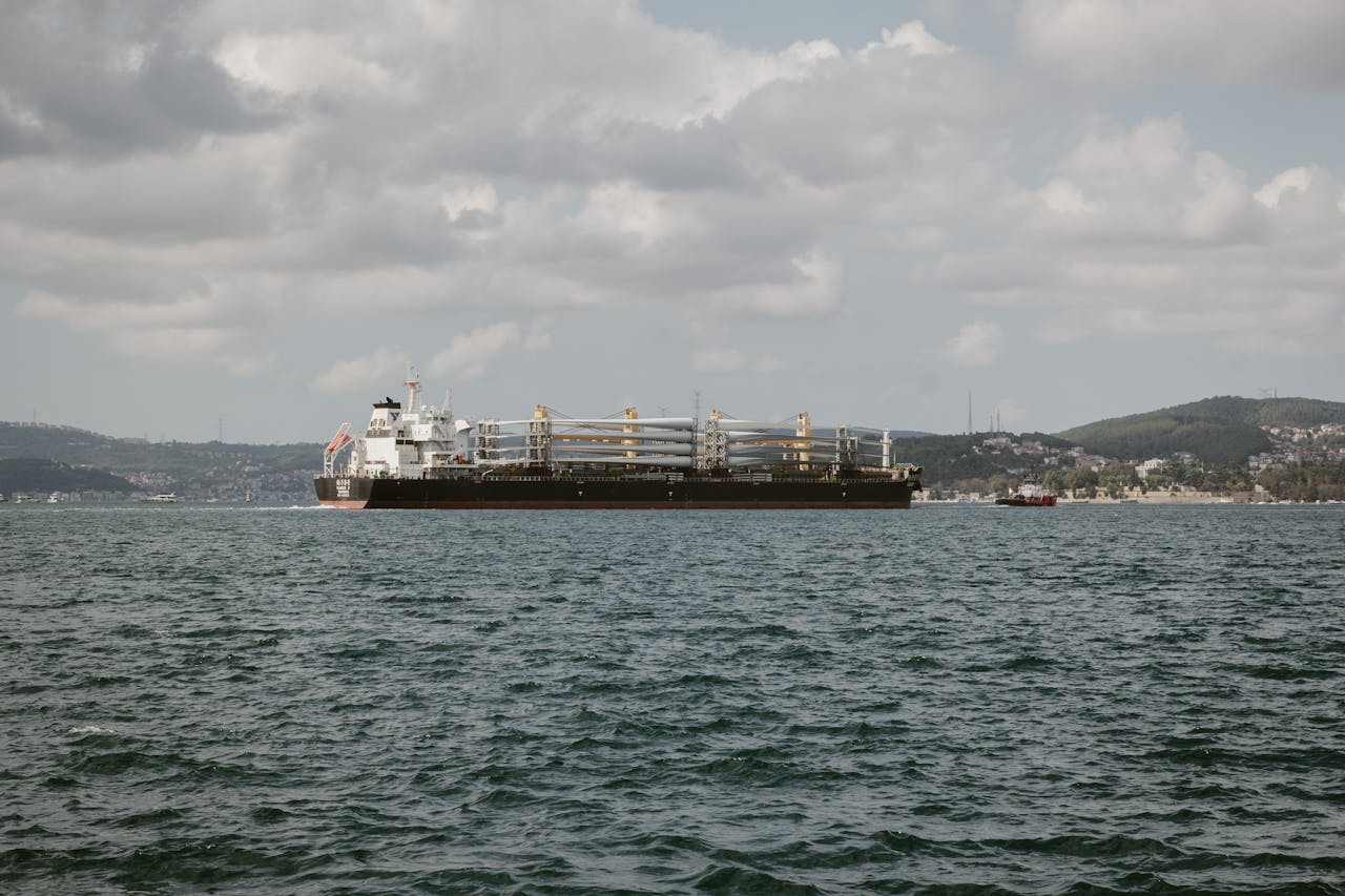 About A large cargo ship sails through the Bosphorus under cloudy skies in Istanbul, Türkiye.